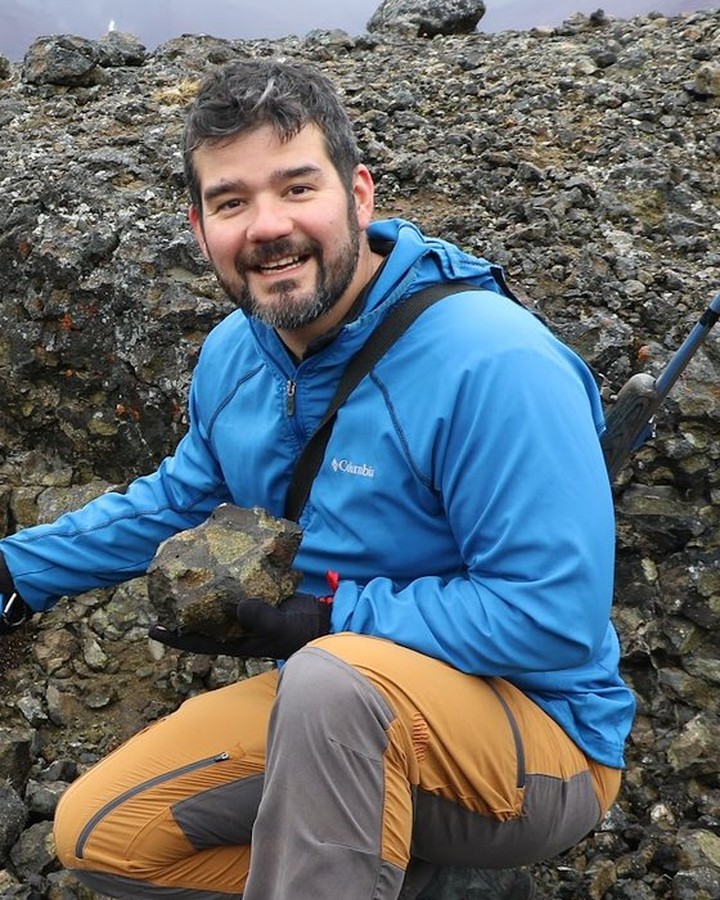 Rafael Kenji Horota examining a rock sample in the field